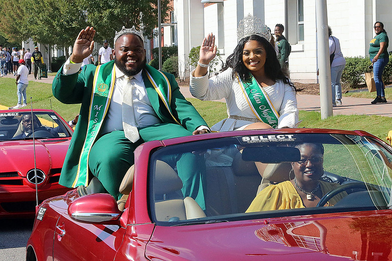 previous mr and ms nsu in the parade featured in a red car