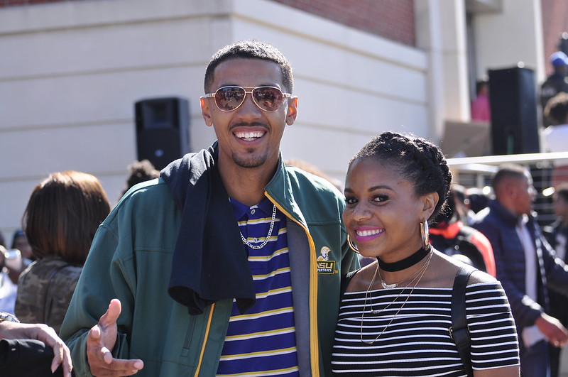 two nsu students smiling while taking a picture in front of the student center