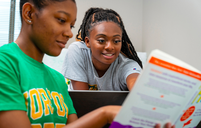students in the dorm reading a book together