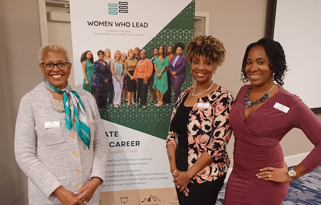 photo of participants in the Women Who Lead event, standing in front of the event marquee.