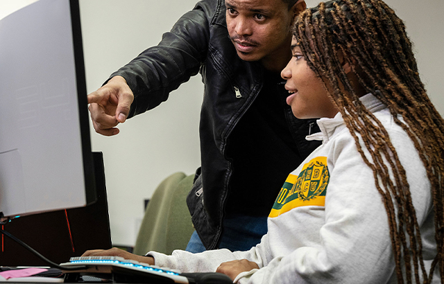 NSU teacher and student looking at computer