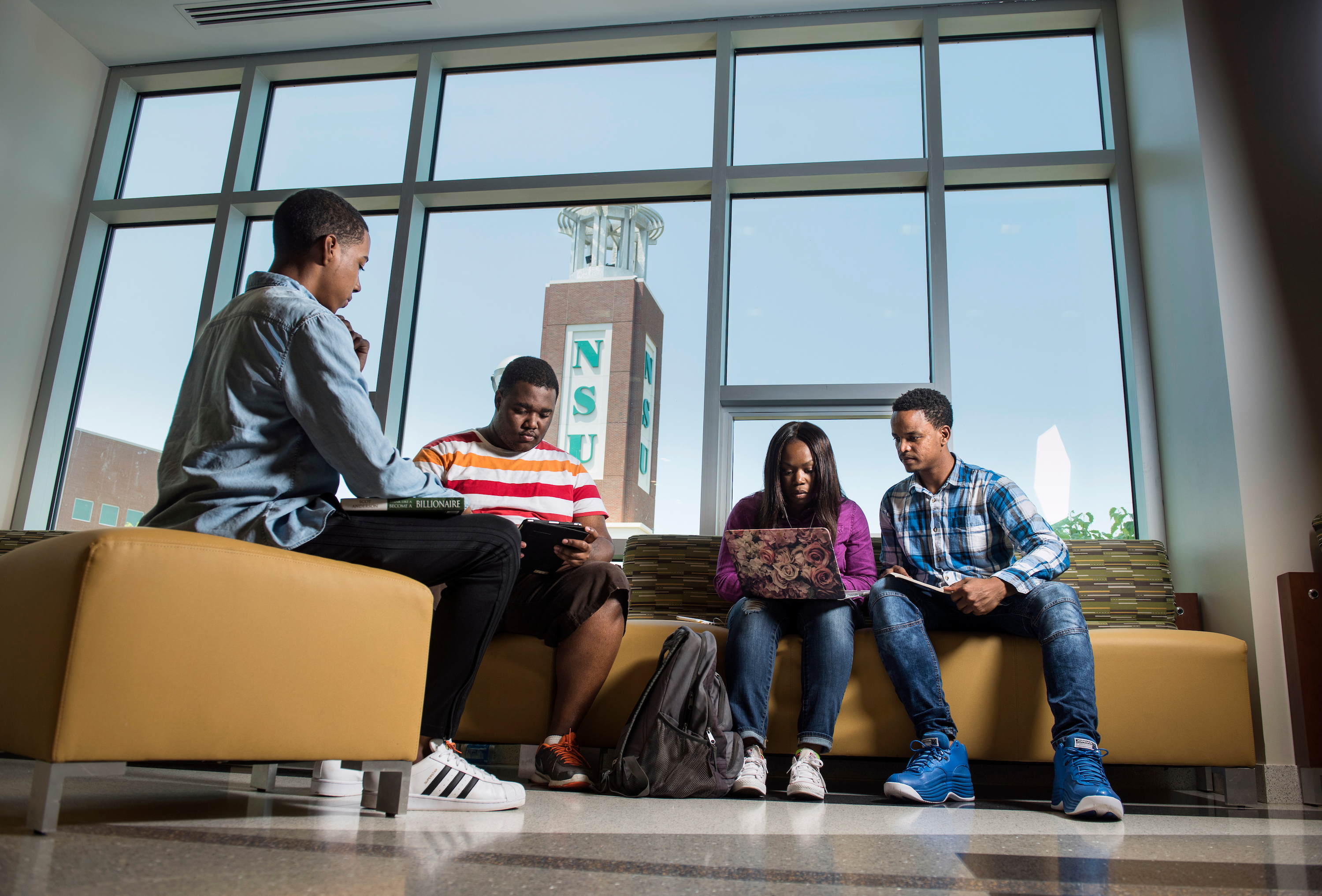 Students sitting in lobby talking and doing homework