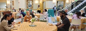 Attendees of the NSU media reception converse at tables.