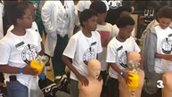 A group of people in white shirts holding mannequins