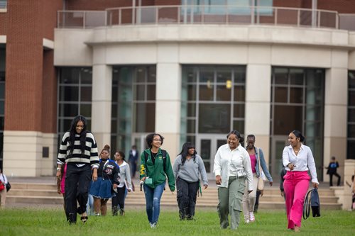 six students walking with the NSU mascot