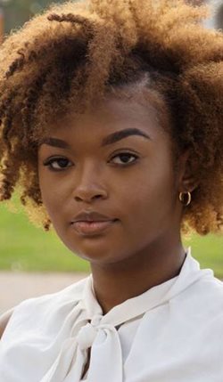 photo of a student with brown hair wearing a white top