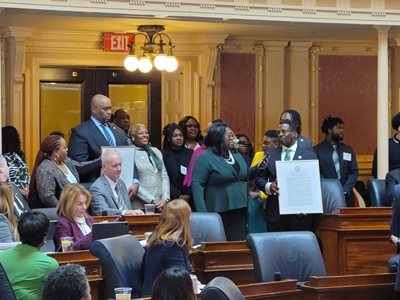Delegate Candi King presents House joint resolution with NSU alumni and guests.